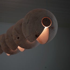 Statement light made from 5 cedar spheres wrapped around a light rod suspended by thin cables.