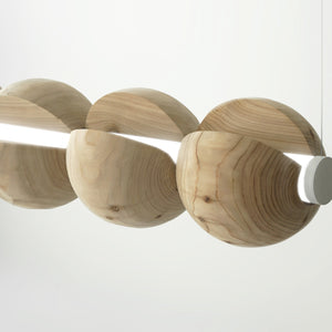Detail shot of a statement light made from 5 cedar spheres wrapped around a light rod suspended by thin cables.