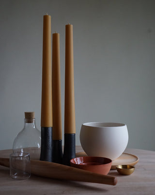various items on a table including: 3 grove candle sticks and holders, a round white grow pot, a glass pitcher and a bowl