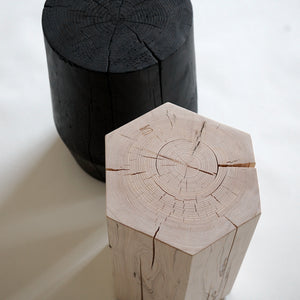 Hexagonal shaped solid hemlock stool with an oiled finish next to a charred black Smokestack stool.