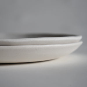 side detail of stack of 2 10" white porcelain dinner plates